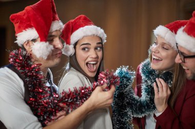 Yeni yıl kutlamalarında bağıran ve poz veren bir grup heyecanlı meslektaşım iş yerindeki tatil atmosferinde koridorda bekliyor. Birlikte, yeni yıl, kutlama