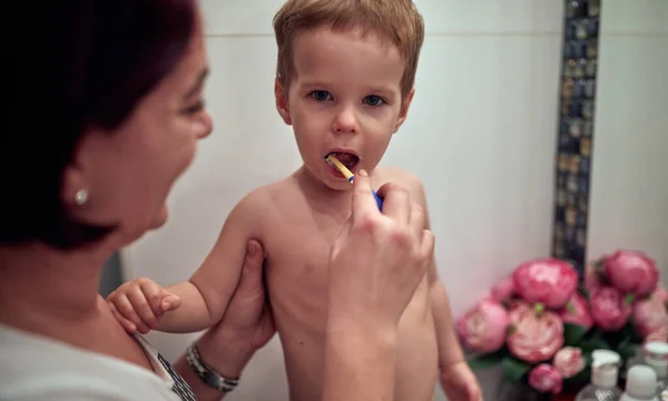 Mãe Ajudando Filhinho Lavar Dentes Banheiro — Fotografia de Stock