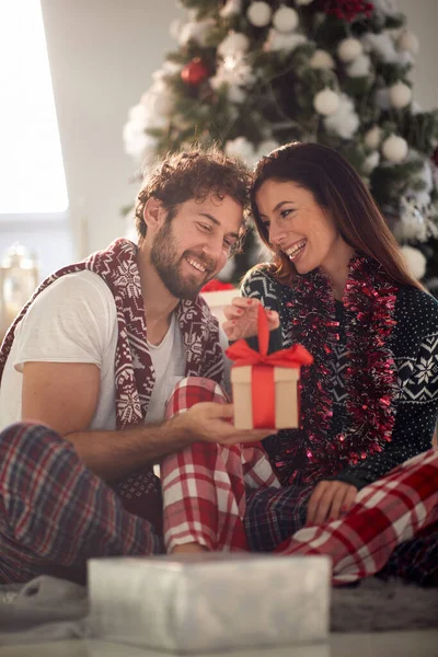 Genç bir çift güzel bir bayram sabahında yerde oturmuş Noel hediyelerinin tadını çıkarıyor. Noel, ilişki, aşk, birlikte