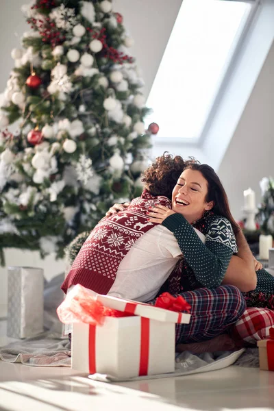 Een Jong Stel Dat Vloer Zit Omringd Door Kerstcadeautjes Knuffelend — Stockfoto