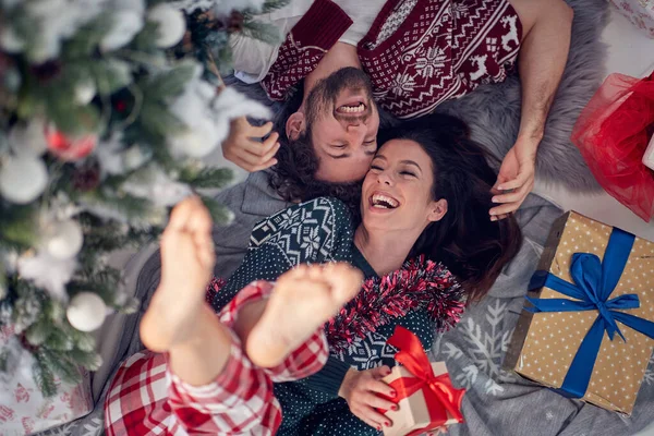 美しい休日の朝にXmasのプレゼントによって一緒に床の上に横になって楽しむ愛の若いカップル クリスマス 一緒に — ストック写真