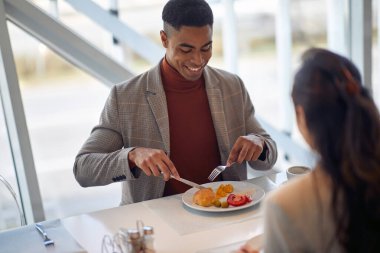 Genç çalışanlar şirket kantininde güzel bir atmosferde öğle yemeği yiyorlar. İnsanlar, iş, şirket, iş kavramı.