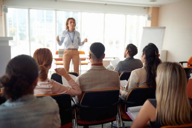 Bir grup iş adamı seminerdeki çalışma ortamındaki bir öğretim görevlisini dikkatle dinliyor. İnsanlar, şirket, iş, iş kavramı.