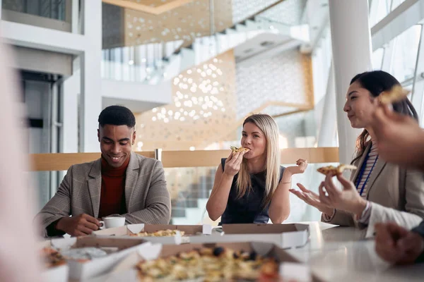 楽しい雰囲気の中で会社の食堂でひと休みしてピザを食べる従業員のグループ ビジネスコンセプト — ストック写真