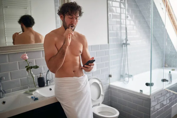 Macho Topless Mężczyzna Smsy Podczas Mycia Zębów Rano — Zdjęcie stockowe