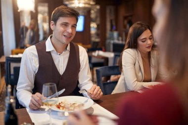 Gençler restoranda rahat bir atmosferde öğle yemeği yemekten zevk alıyorlar. İş, restoran, öğle yemeği