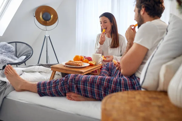Ett Ungt Par Äter Utsökta Apelsiner Frukost Sängen Sitt Sovrum — Stockfoto