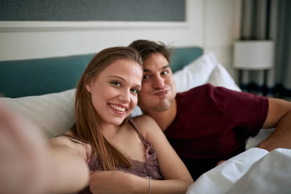Young Couple Bed Hotel Room Enjoying Vacation Taking Funny Selfies — Stock Photo, Image