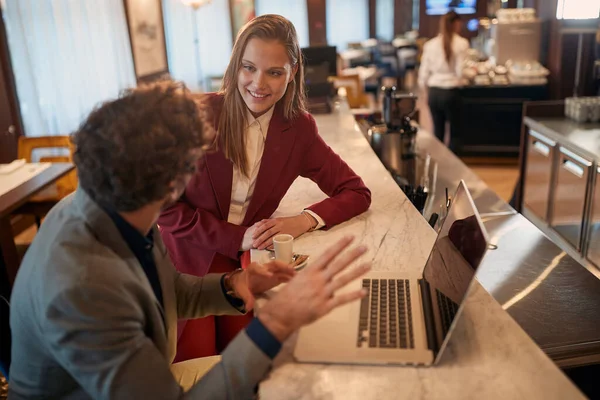 バーでコーヒーブレイクでリラックスした雰囲気の中で若いビジネスマンが 彼の女性同僚に新しいビジネス契約を説明しています ビジネス — ストック写真