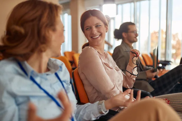 people in conference room at business seminar. two caucasian  females talking