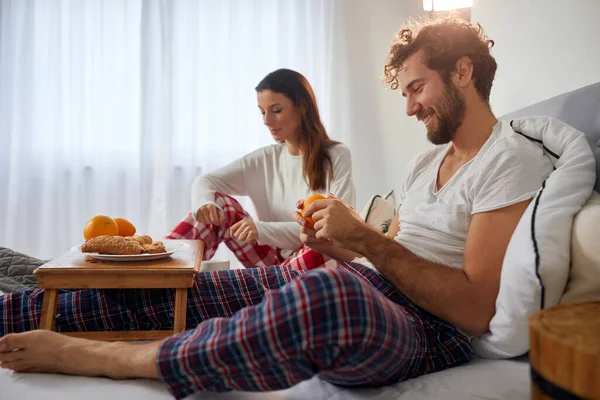 Een Jongeman Met Vriendin Bed Slaapkamer Die Een Sinaasappel Afpelt — Stockfoto