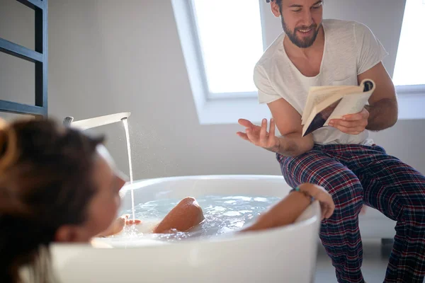 Young Guy Enjoying Reading Book His Girlfriend Who Enjoying Bath — Stock Photo, Image