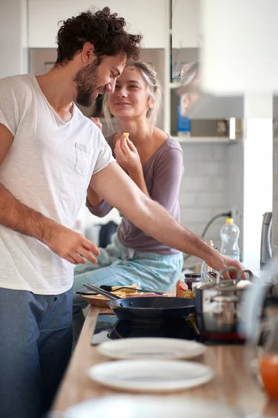 家の雰囲気の中でガールフレンドの食事の準備を楽しんでいる若い男 キッチン — ストック写真