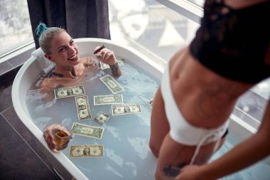 Genç, seksi, lezbiyen bir çift banyoda rahat bir atmosferde banyo yapıyorlar. Puro, içki ve suda bir sürü parayla. Aşk, ilişki, lüks, banyo, lgbt