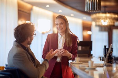 Genç neşeli iş arkadaşları, barda rahat bir atmosferde kahve molası verirken sohbet ediyorlar. İş, insanlar, bar.