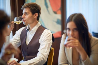 Genç çift, restoranda rahat bir atmosferde iş yemeğinde içki içiyor. İş, restoran, öğle yemeği