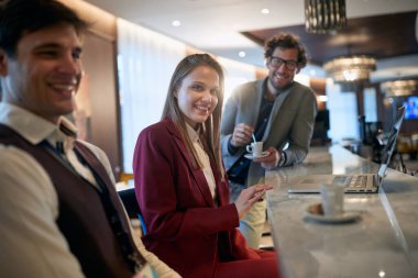 Genç bir iş kadını iş arkadaşlarıyla kahve molası veriyor ve rahatlamış bir ortamda poz veriyor. İş, insanlar, bar.