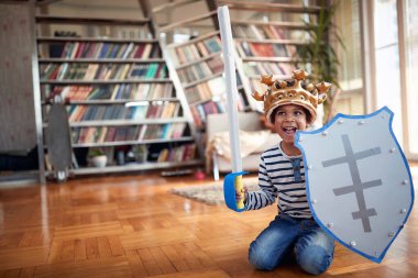 Evde neşeli bir atmosferde yerde oynayan sevimli küçük bir çocuk. Aile, birlikte, aşk, oyun zamanı