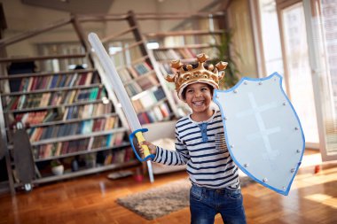 Sevimli küçük bir çocuk evde neşeli bir atmosferde oynarken fotoğraf için poz veriyor. Aile, birlikte, aşk, oyun zamanı