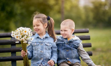 Anaokulundaki arkadaşının ona verdiği gülümsemeyle küçük sevimli bir kız. Bir kova çiçek.