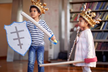 Şövalyeler gibi giyinmiş küçük bir kız ve erkek kardeş evde neşeli bir atmosferde oynuyorlar. Aile, ev, oyun zamanı