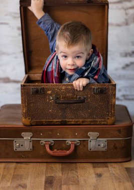 Küçük çocuk bavulda oynuyor, konsept çocukluk ve seyahat 