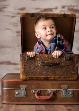 Kırsal bavulda oturan küçük çocuk.