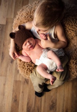 Küçük çocuk yeni doğan kardeşiyle oynuyor.