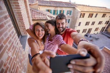 Güneşli bir günde selfie çeken bir grup mutlu arkadaş.