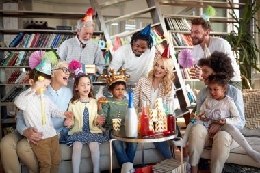 Büyük, etnik çeşitlilikte bir aile evde doğum gününü kutluyor.