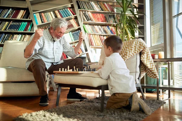 Χαρούμενος Παππούς Και Εγγονός Παίζουν Σκάκι Μαζί Στο Σπίτι — Φωτογραφία Αρχείου