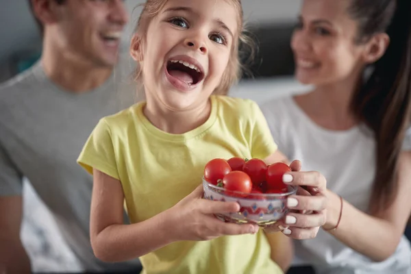 소녀가 부모와 분위기 가운데 토마토 그릇을 사진을 있었다 — 스톡 사진