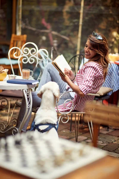 Νεαρό Κορίτσι Διαβάζει Ένα Βιβλίο Ενώ Περνούν Ένα Χρόνο Σκυλί — Φωτογραφία Αρχείου