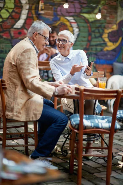 Older Couple Watching Smartphone Content While Having Drink Relaxed Atmosphere — Fotografia de Stock