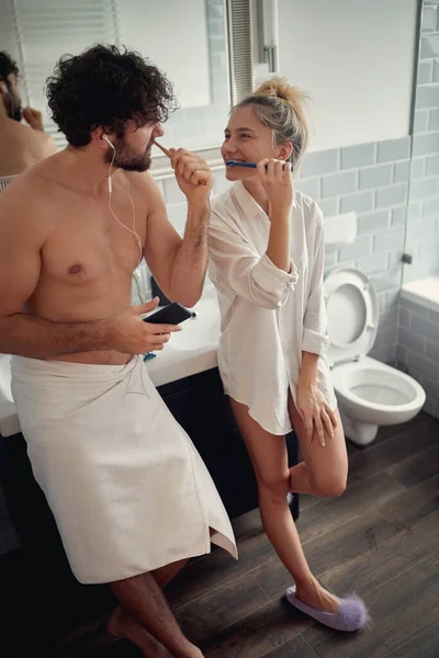 年轻夫妇在浴室里一起刷牙 互相望着 玩得很开心 情人节 — 图库照片