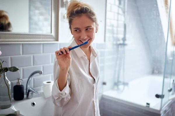 Satisfied Young Adult Caucasian Blonde Female Thinking Smile While Brushing — Stock Photo, Image