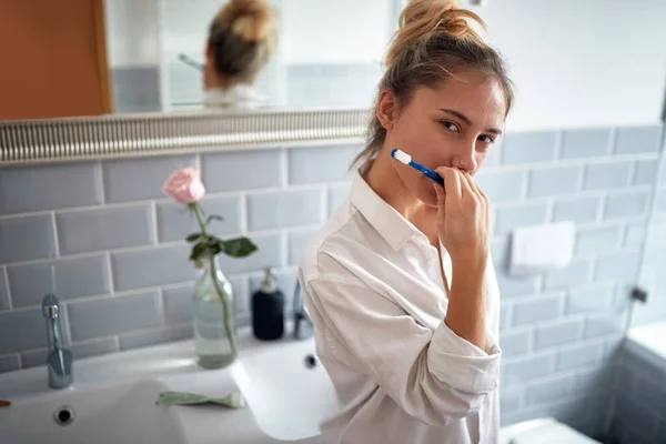 Young Adult Caucasian Blonde Female Seductively Looking Camera While Brushing — Stockfoto