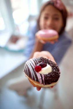 Bir pastanenin hoş atmosferinde genç ve güzel bir kızın tuttuğu çöreğin yakın çekimi. Pastane, tatlı, tatlı