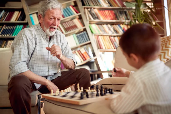 Ένας Χαρούμενος Παππούς Απολαμβάνει Παίζει Σκάκι Τον Εγγονό Του Ενώ — Φωτογραφία Αρχείου