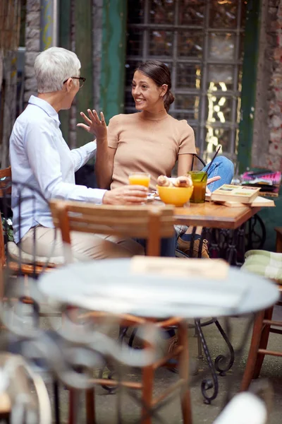나이든 여자와 의젊은 친구는 바에서 분위기로 이야기하면서 흥분한다 — 스톡 사진