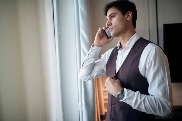 Pensativo Jovem Caucasiano Masculino Falando Telefone Celular Pela Janela Apertando — Fotografia de Stock