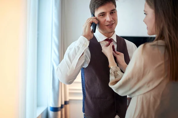 Joven Mujer Caucásica Arreglando Una Corbata Joven Hombre Hablando Teléfono — Foto de Stock