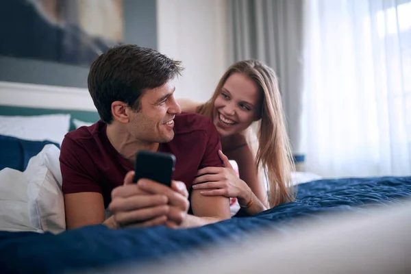若い白人の大人のカップルはベッドに横になって笑って楽しんで楽しい時間を過ごしています — ストック写真