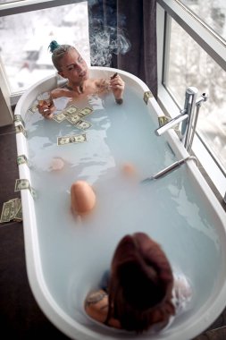 Seksi lezbiyen çift küvette birlikte eğleniyor; hedonistik yaşam tarzı