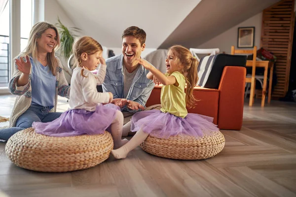 一个年轻的家庭坐在地板上 在愉快的气氛中一起在家里玩得很开心 游戏时间 — 图库照片