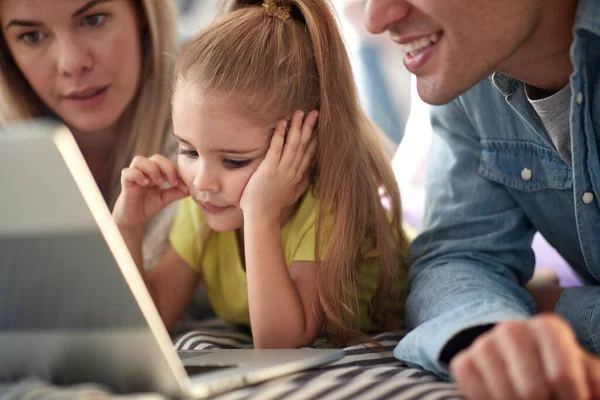 Liten Flicka Tittar Bärbar Dator Innehåll Med Sina Föräldrar Avslappnad — Stockfoto