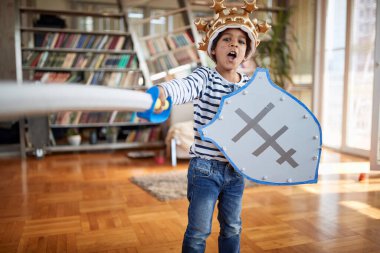Evde neşeli bir atmosferde fotoğraf çektirirken bağıran ve saldıran küçük sevimli bir şövalye. Aile, birlikte, aşk, oyun zamanı