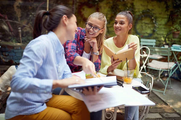 三位年轻的白人女性在户外咖啡馆一起学习 玩得很开心 — 图库照片