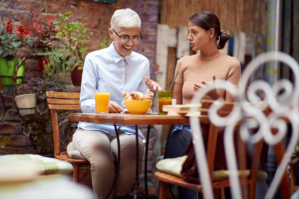 Молодая Белая Женщина Разговаривает Пожилой Женщиной Объясняя Завтраком Вместе — стоковое фото