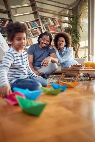 小さな男の子が家庭の雰囲気の中で遊んでいるのを見ている若い両親 一緒に 遊びの時間 — ストック写真